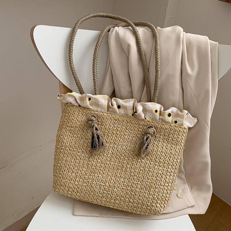 Strohtasche aus geflochtenem Raffia in Weiss und Khaki, ideal für den Sommer, mit Kordelzugöffnung und Doppelseitigen Tragegriffen.