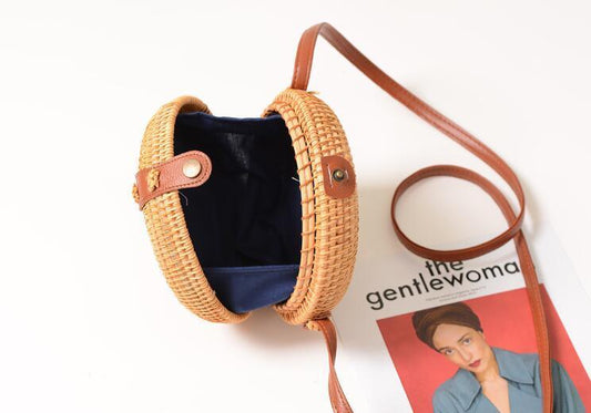 Runde Schultertasche aus Rattan mit handgefertigtem Design, ideal für sommerliche Looks.