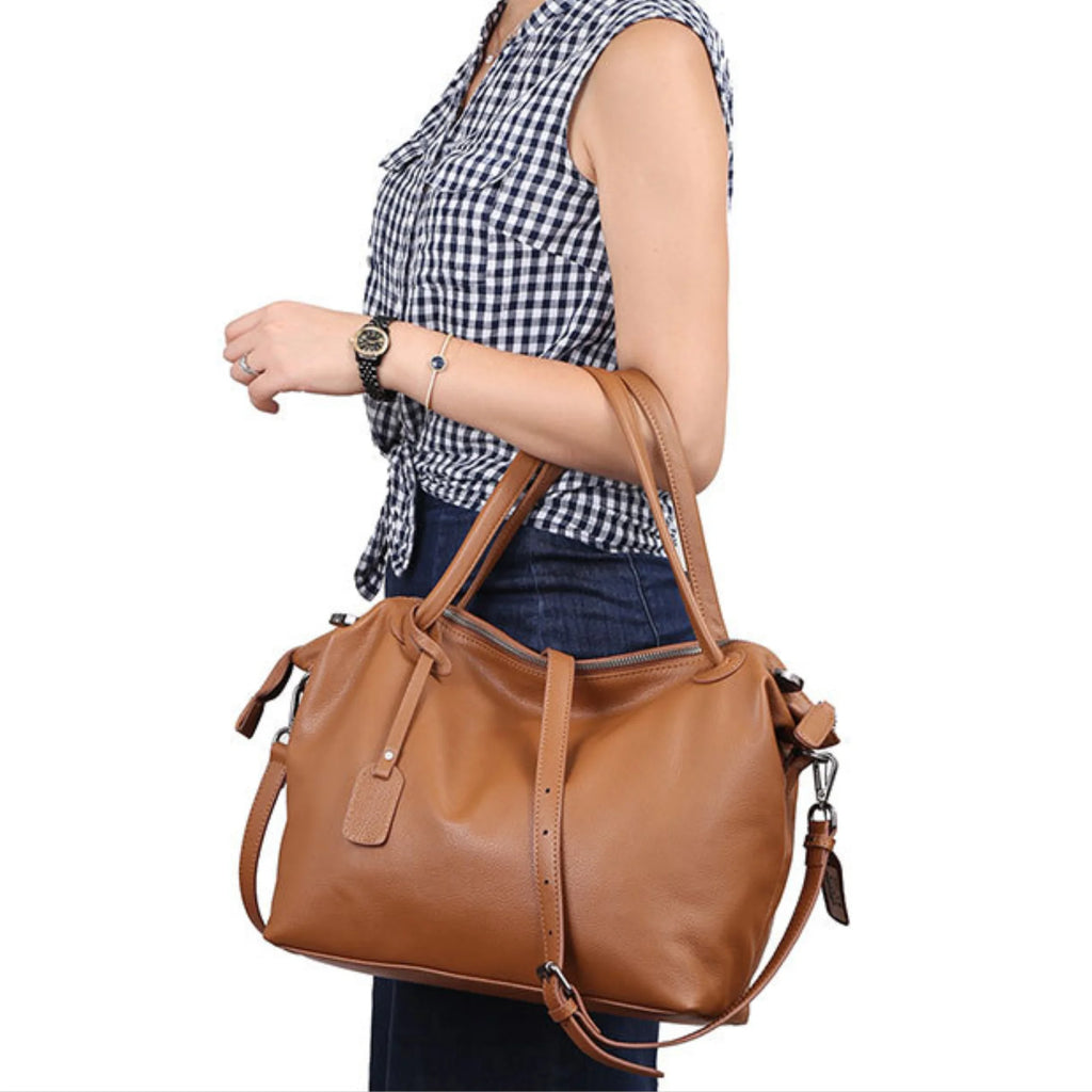 Lederhandtasche in Cognac, getragen mit kurzem Griff und Crossbody-Gurt im Casual Look