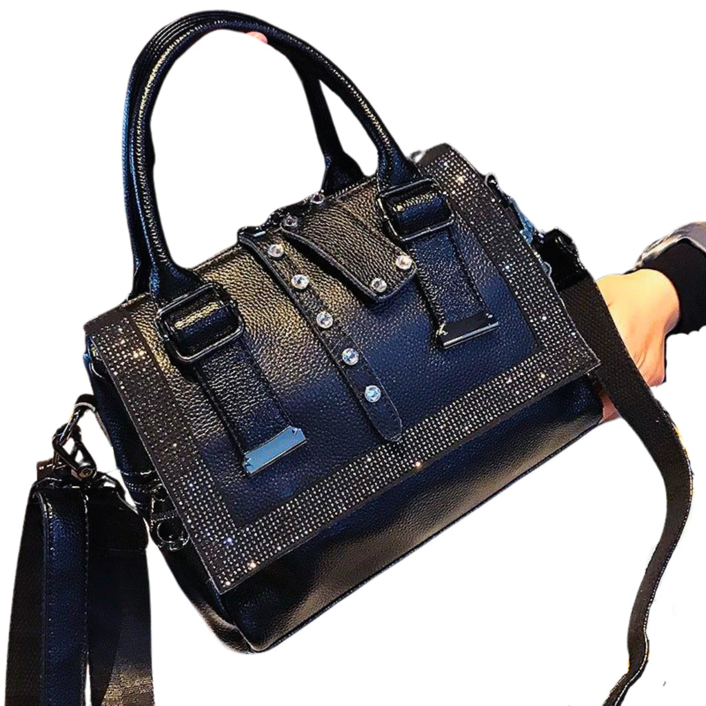 Strassdetails leuchten auf schwarzer Tasche, geometrische Struktur und breite Gurte