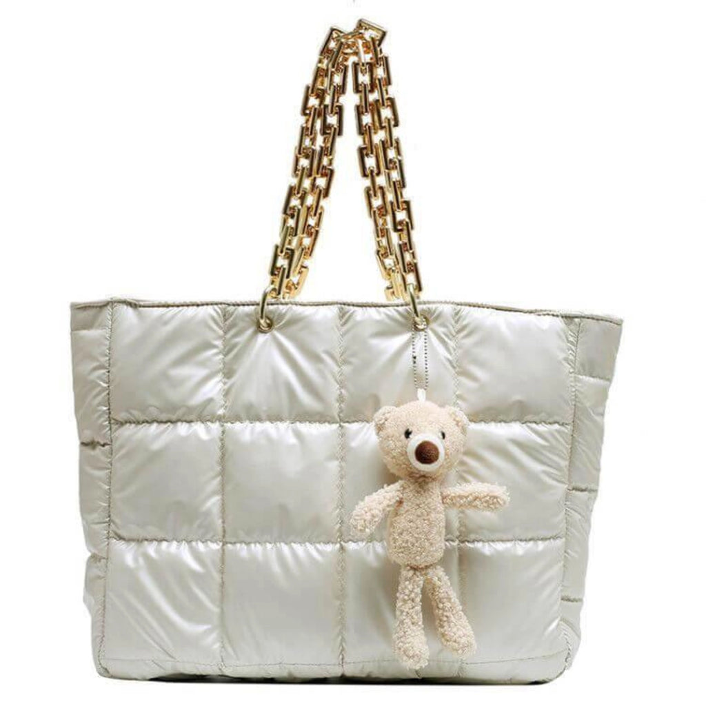 Gepolsterte Tasche in Beige im Querformat mit Plüschbär und goldener Kettenträgerin