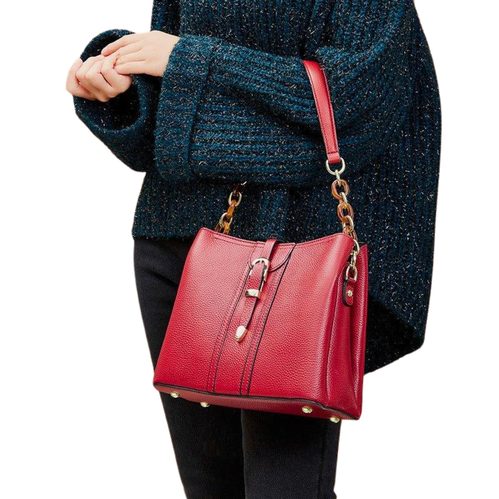 Weinrote Echtleder-Bucket-Bag mit Perlenschnalle und Goldkette, urban getragen