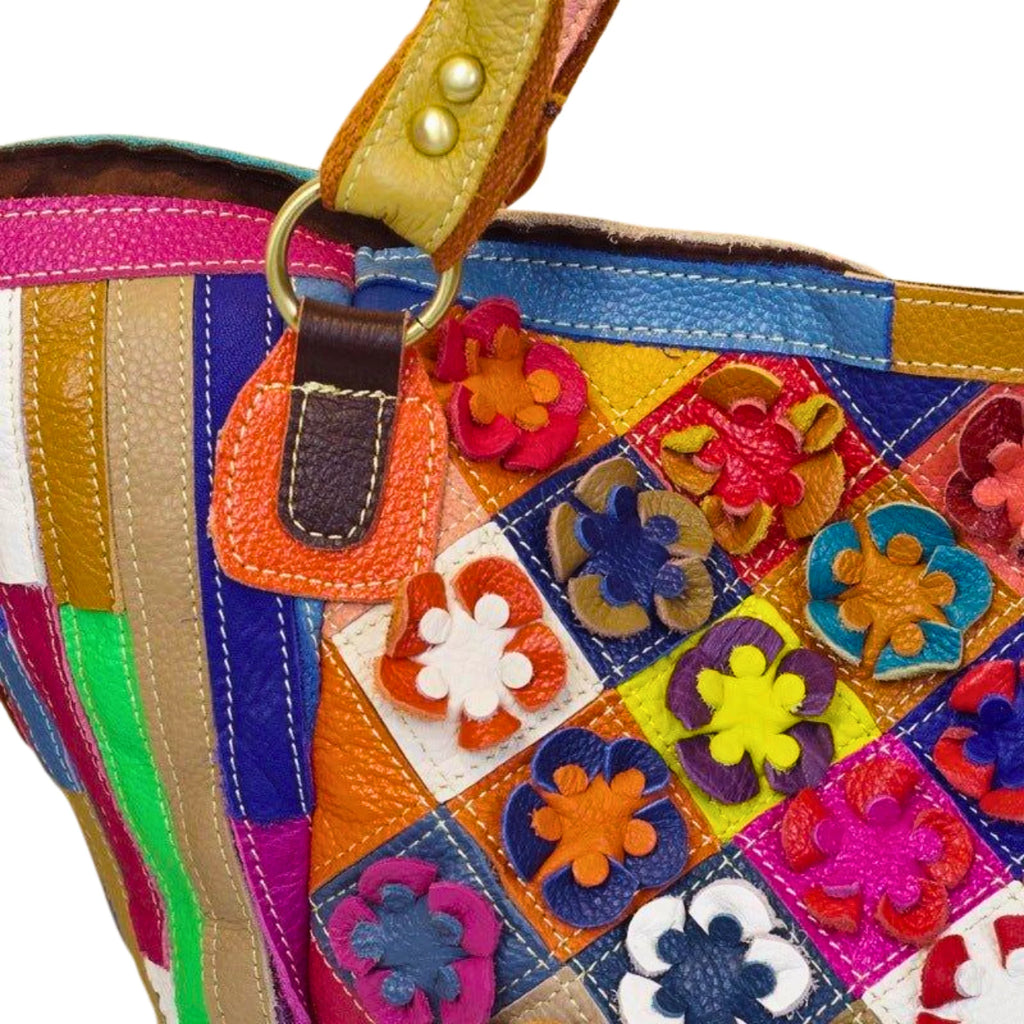 Nahaufnahme: Henkel-Öse, farbiges Leder, doppelt vernähte Blumenapplikationen