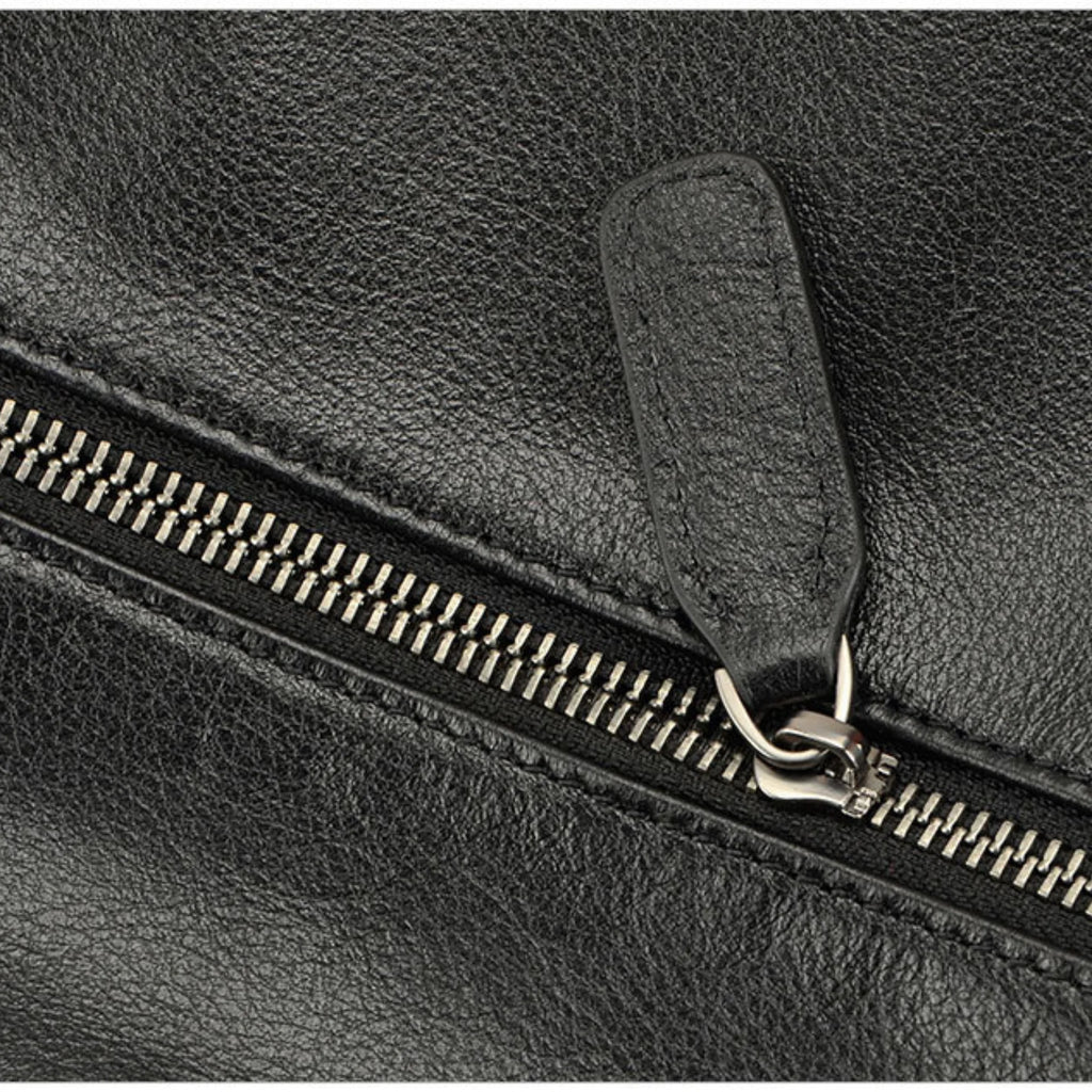 Nahaufnahme des robusten Reissverschlusses mit Lederanhänger an schwarzer Echtledertasche