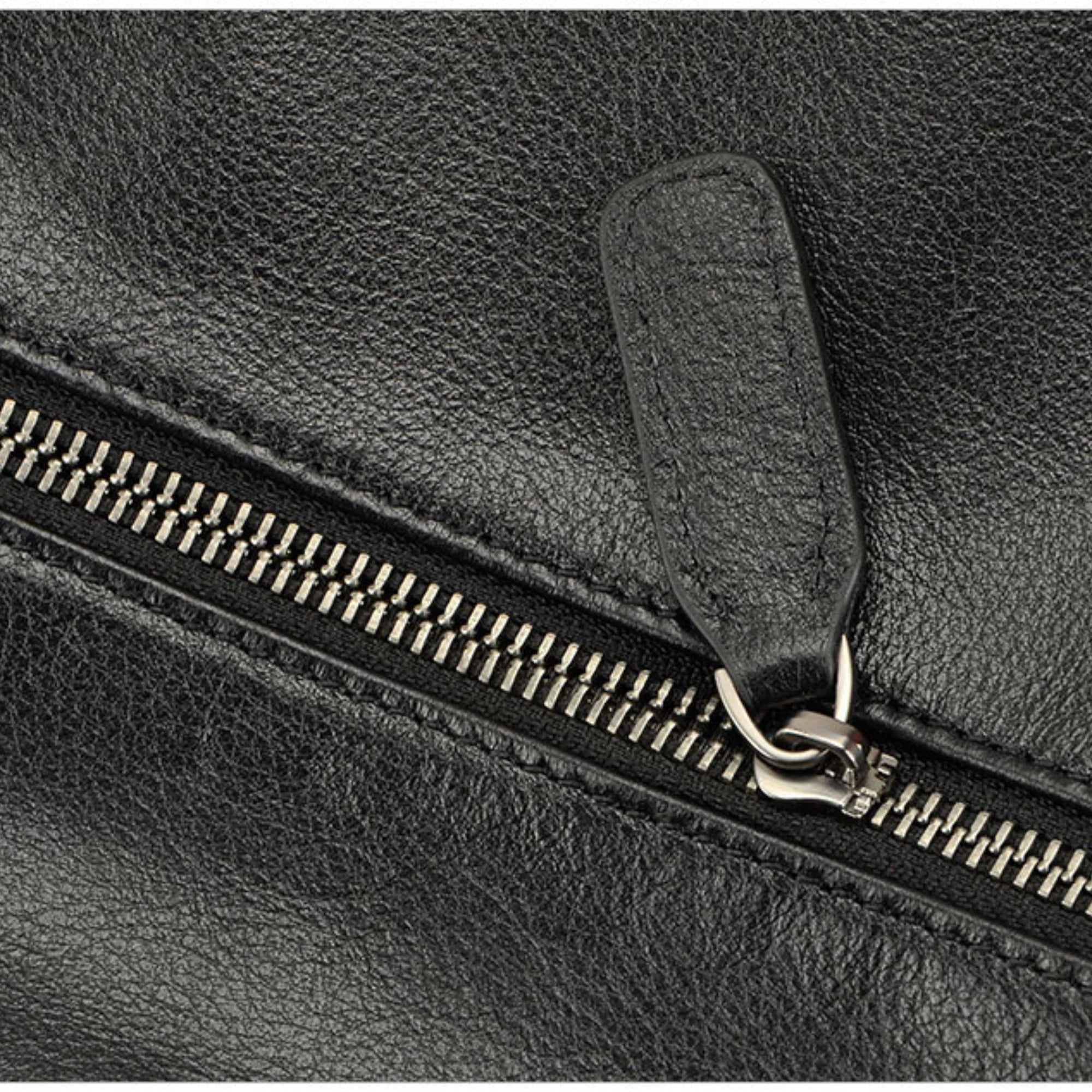 Nahaufnahme des robusten Reissverschlusses mit Lederanhänger an schwarzer Echtledertasche
