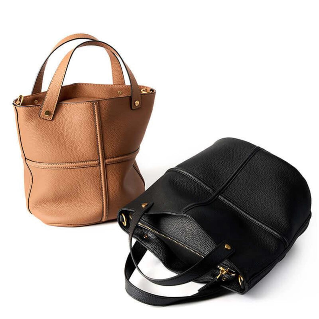 Zwei minimalistische Echtleder-Shopper in Schwarz und Cognac mit klarer Linienführung und goldener Hardware