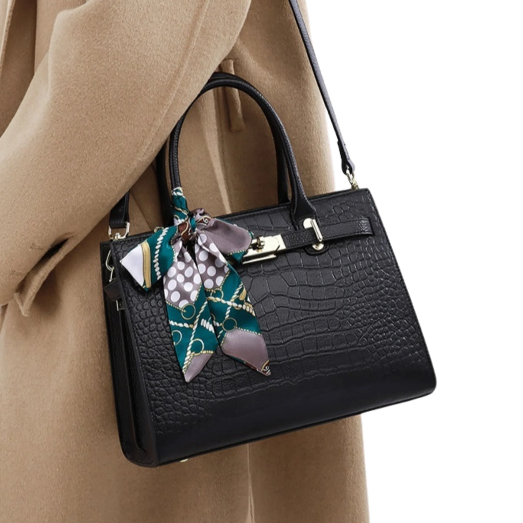 Schwarze Croco-Handtasche mit gemustertem Halstuch, getragen zu beigem Mantel