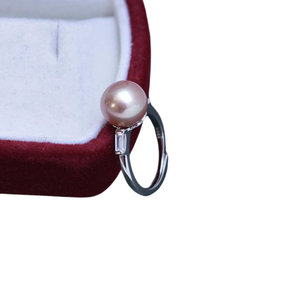 Silberring mit rosa Perle und Zirkonfassung, offen tragbar, platziert in einem roten Etui