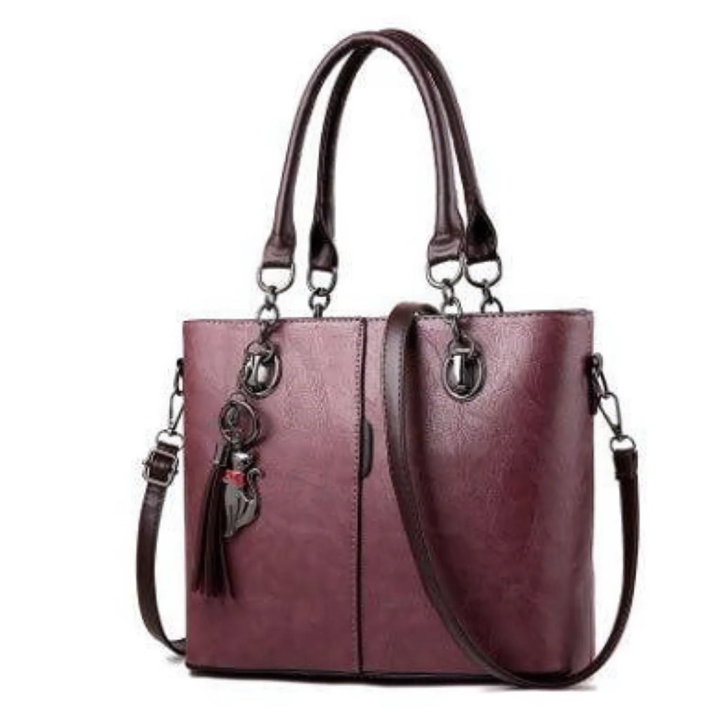 Dunkelviolette Handtasche mit urbanem Format, strukturiertem Finish und dekorativem Tassel