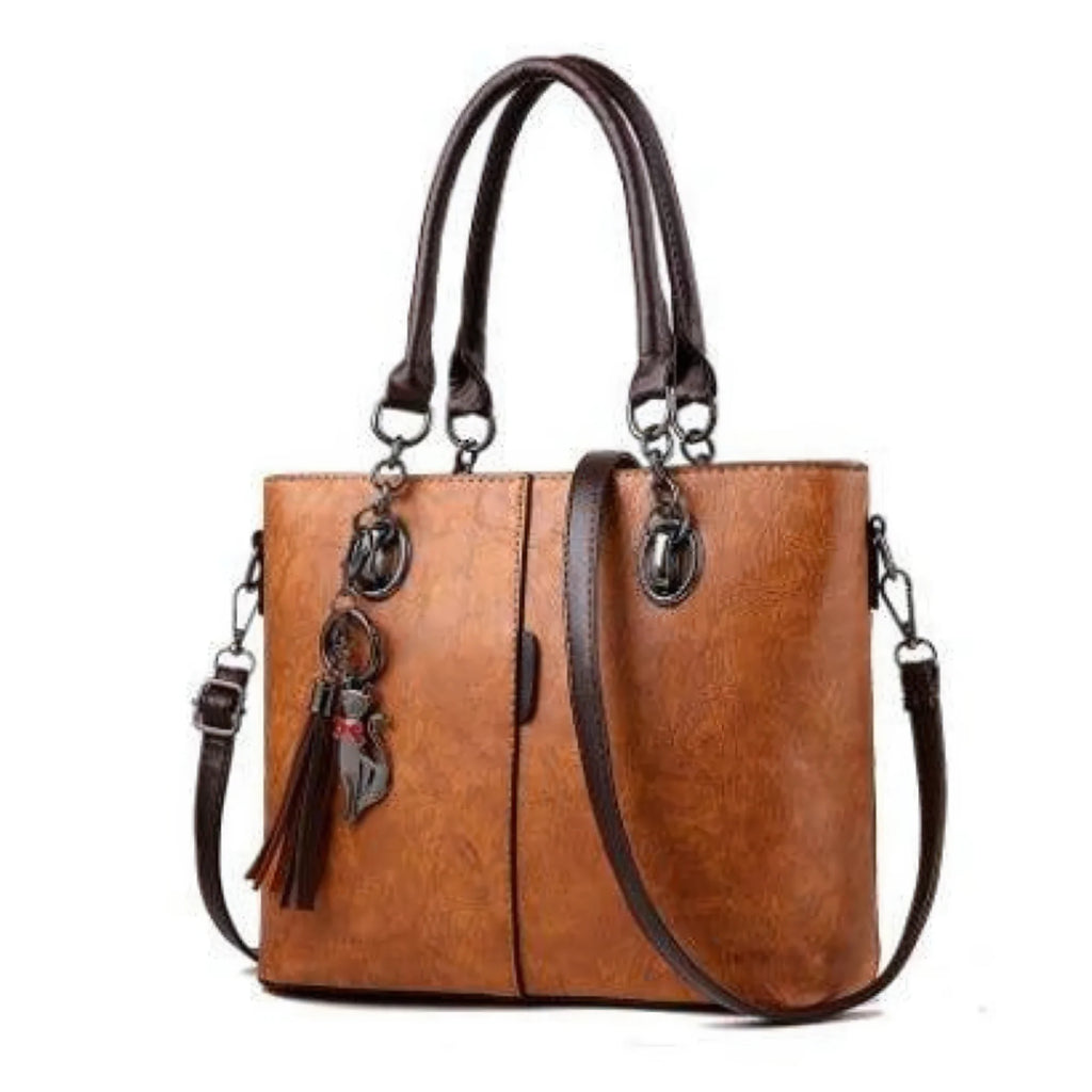 Damenhandtasche in Cognacbraun mit robuster Nahtprägung und Quastenanhänger