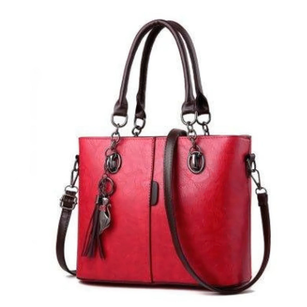 Graue Tasche mit stabiler Struktur, dunklem Griff und Tasselanhänger – ideal für Büro und Alltag