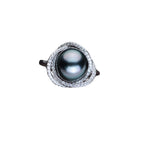 Ring mit schwarzer Perle und geschlossener Spiralstruktur aus glänzendem Silber
