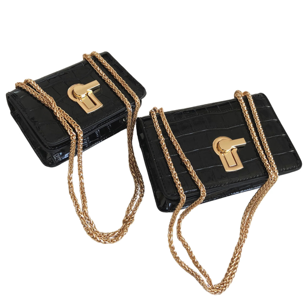 Zwei edle schwarze Damenhandtaschen mit Krokoprägung und Kettenriemen