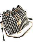 Hahnentrittmuster-Bucketbag mit schwarzem Kettenriemen und dezentem Zugband – grafisch, klar