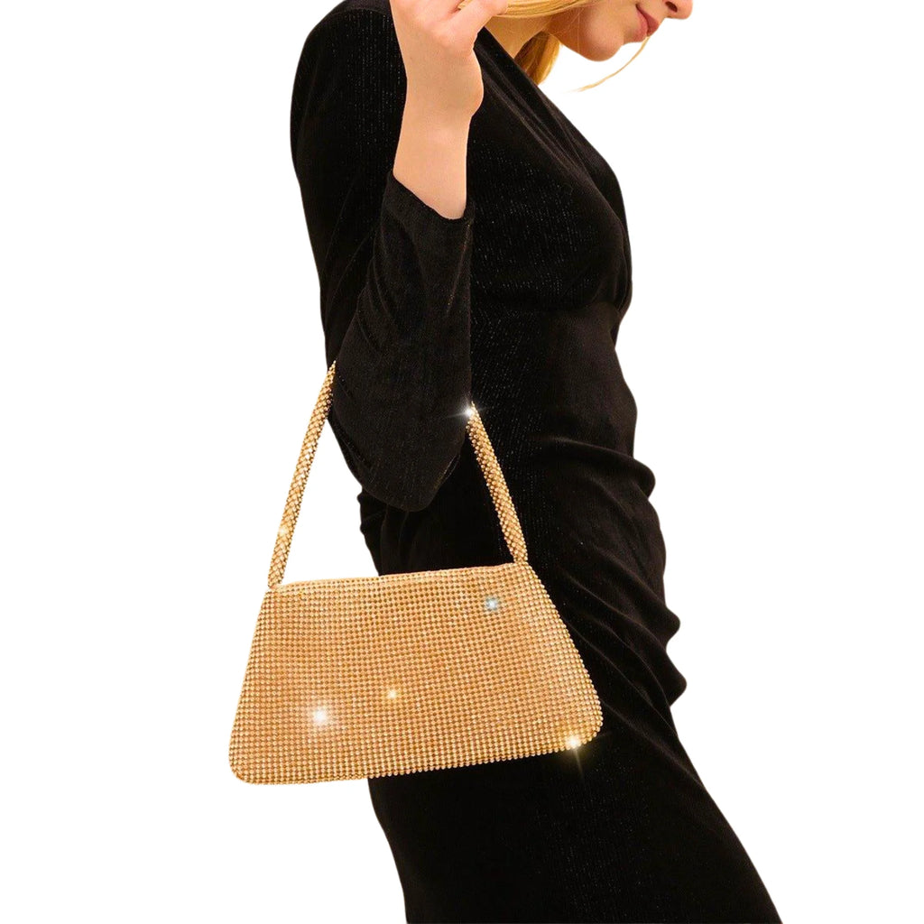 Goldene Strass-Clutch mit Blattverschluss – elegant getragen zum schwarzen Kleid