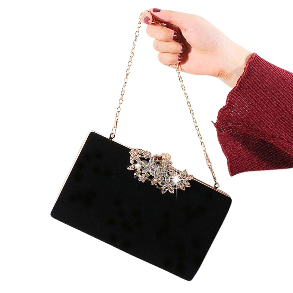 Abendtasche in Schwarz mit floraler Verzierung und feiner Metallkette – kombiniert mit Bordeaux-Outfit