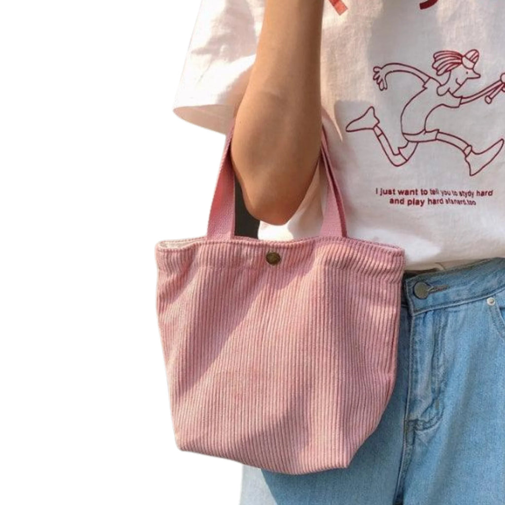 Rosa Cordtasche in Dusty Rose, minimalistisch über der Hand getragen