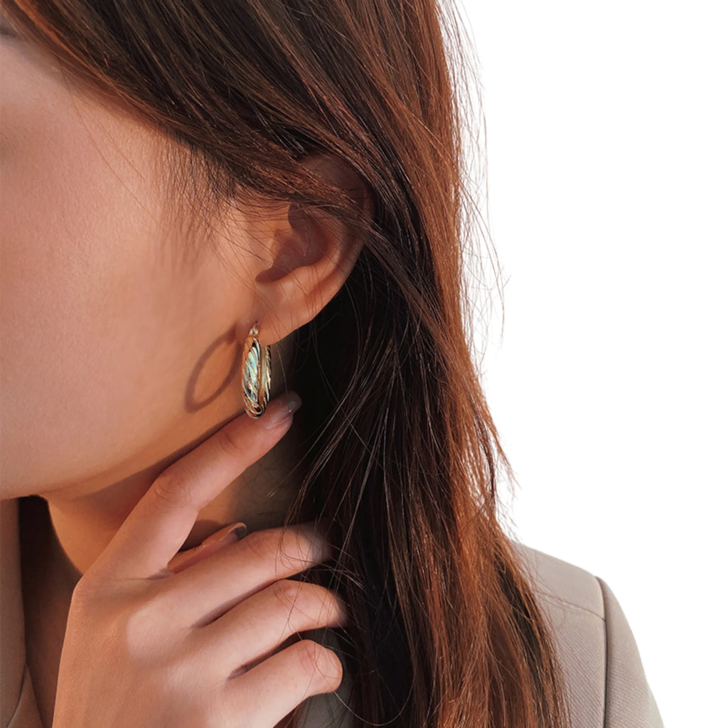 Getragene Creolen in Goldoptik mit sanfter Drehrillenstruktur