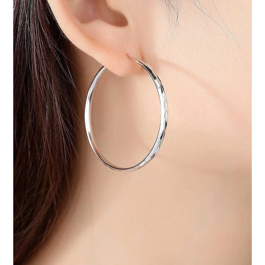 Runde Creole mit Lin-Prägung aus platinbeschichtetem Silber, getragen am Ohr