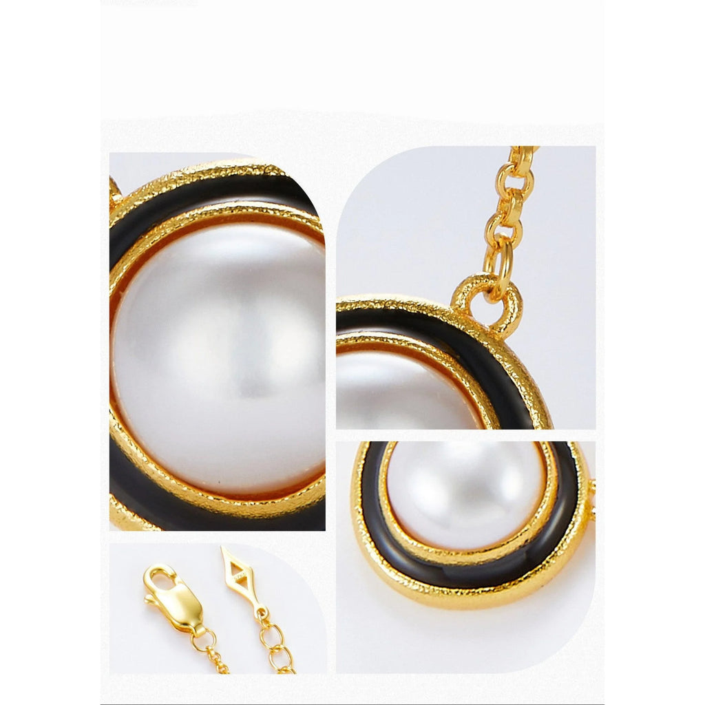 Makroaufnahme eines runden Perlenanhängers mit strukturierter Goldfassung und schwarzem Rand auf vergoldeter Silberkette