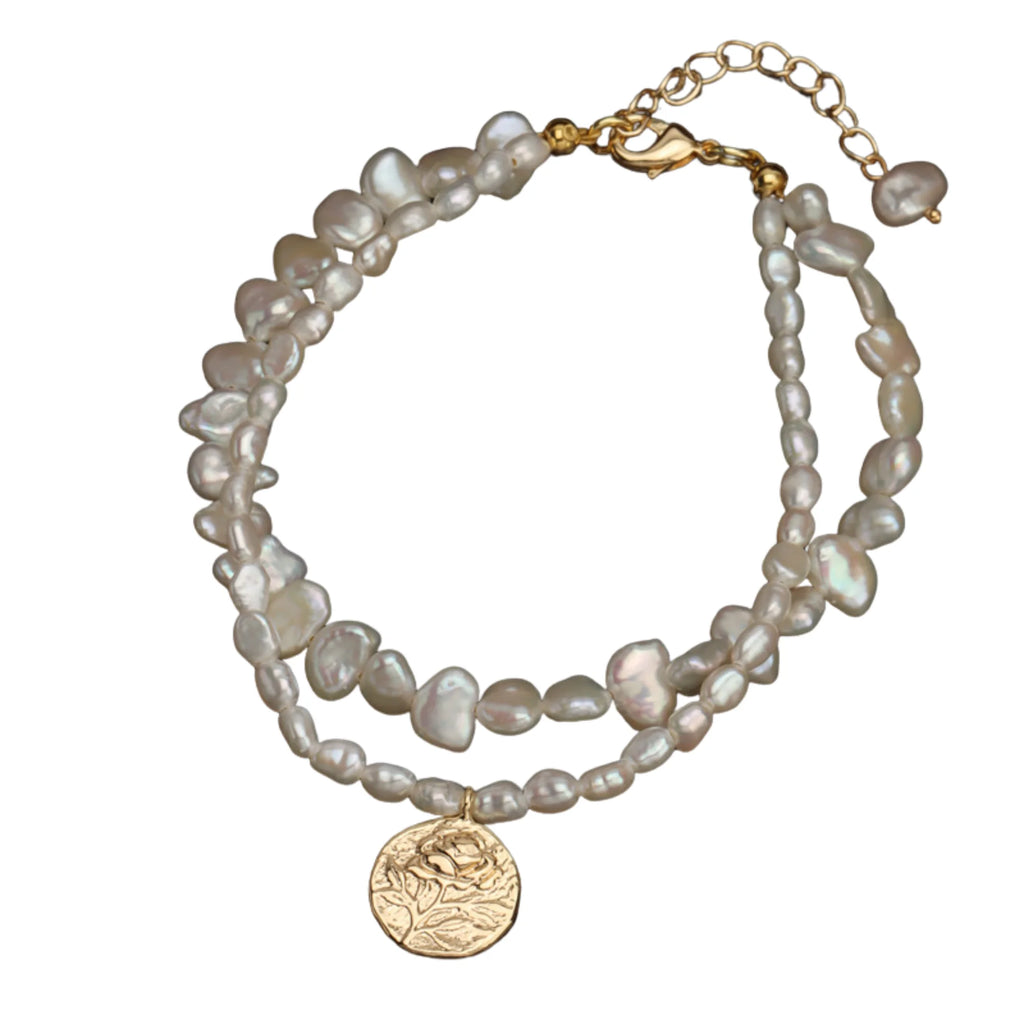 Layering-Armband mit goldfarbigem Coin auf zwei Perlensträngen – getragen über schwarzem Stoff