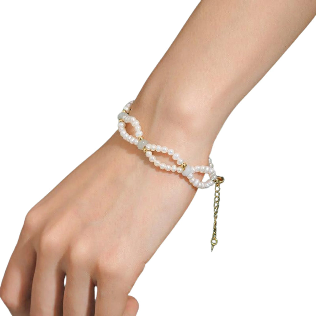 Armband mit zwei Strängen Süsswasserperlen und goldfarbenen Akzenten – getragen am Handgelenk