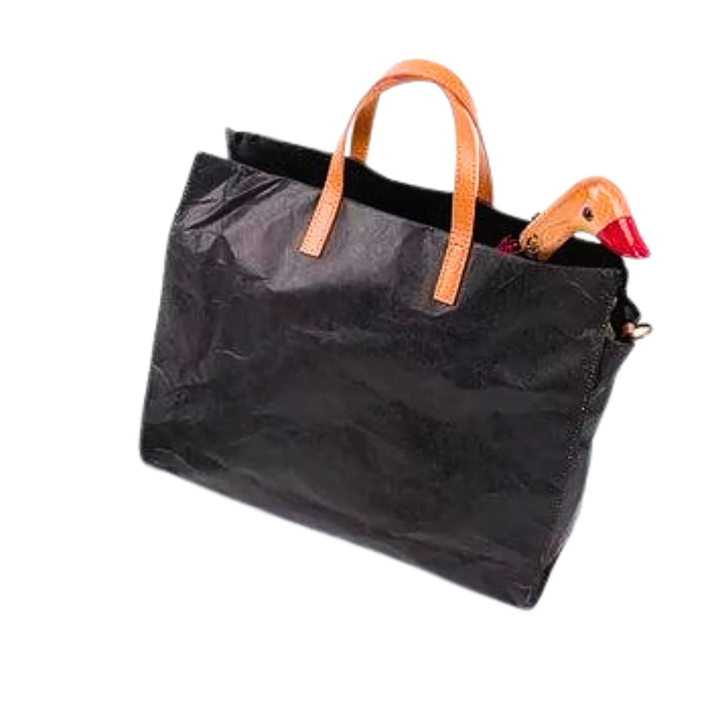 Tasche aus Dupont-Papier in Shadow Black mit braunen Henkeln, Holzgrifffigur schaut aus dem Hauptfach