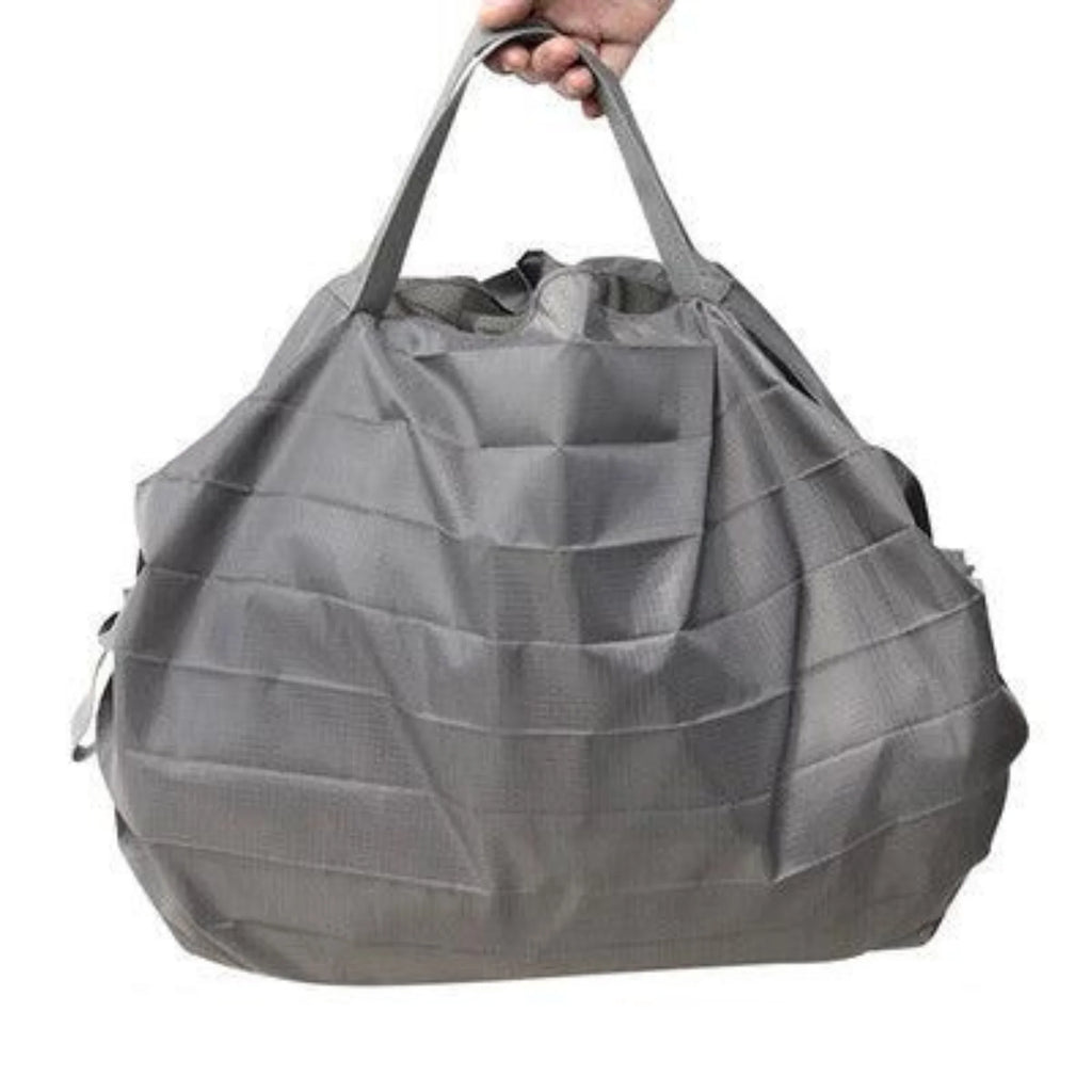 Faltbare Tragetasche aus Nylon in Stone Grey mit strukturierter Oberfläche, in der Hand gehalten