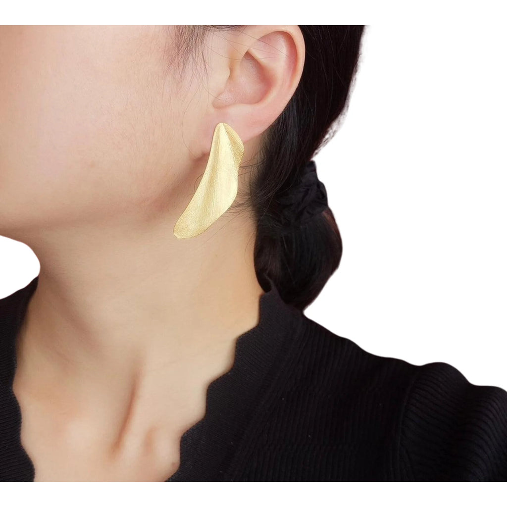Asymmetrischer Flächen-Ohrring in Gold, getragen am Ohr