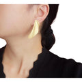 Asymmetrischer Flächen-Ohrring in Gold, getragen am Ohr