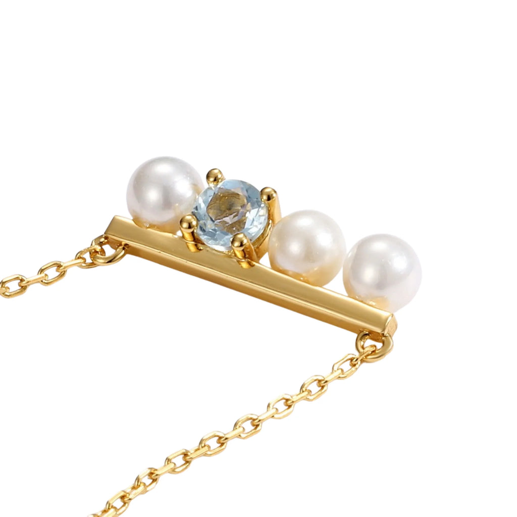 Nahaufnahme der grafisch aufgebauten Goldkette mit Topas und Perlen