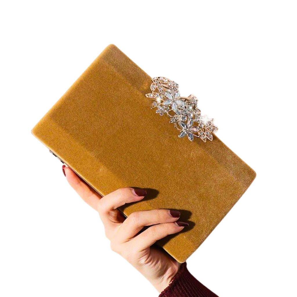 Samtige Clutch in Goldton mit floraler Kristallapplikation – festlich getragen zur Hochzeitsfeier