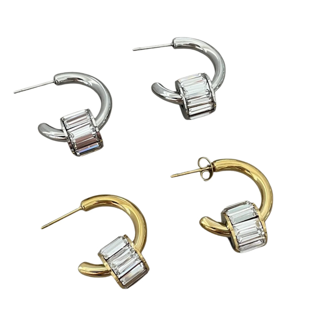 Geöffnete Halbkreis-Ohrringe in Silber und Gold – strukturiert abgelegt mit sichtbarem Steckverschluss