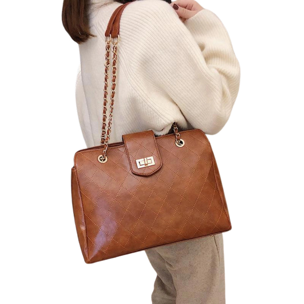 Cognacfarbene Tasche mit Kettenelement – kombinierbar mit hellen Tönen und klarer Silhouette