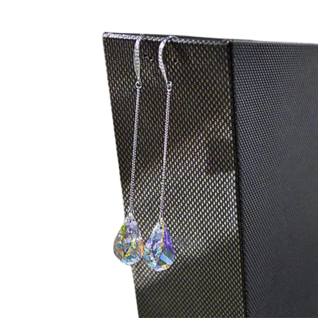 Zwei lange Tropfenohrringe mit Kristallen, hängend auf strukturiertem Display