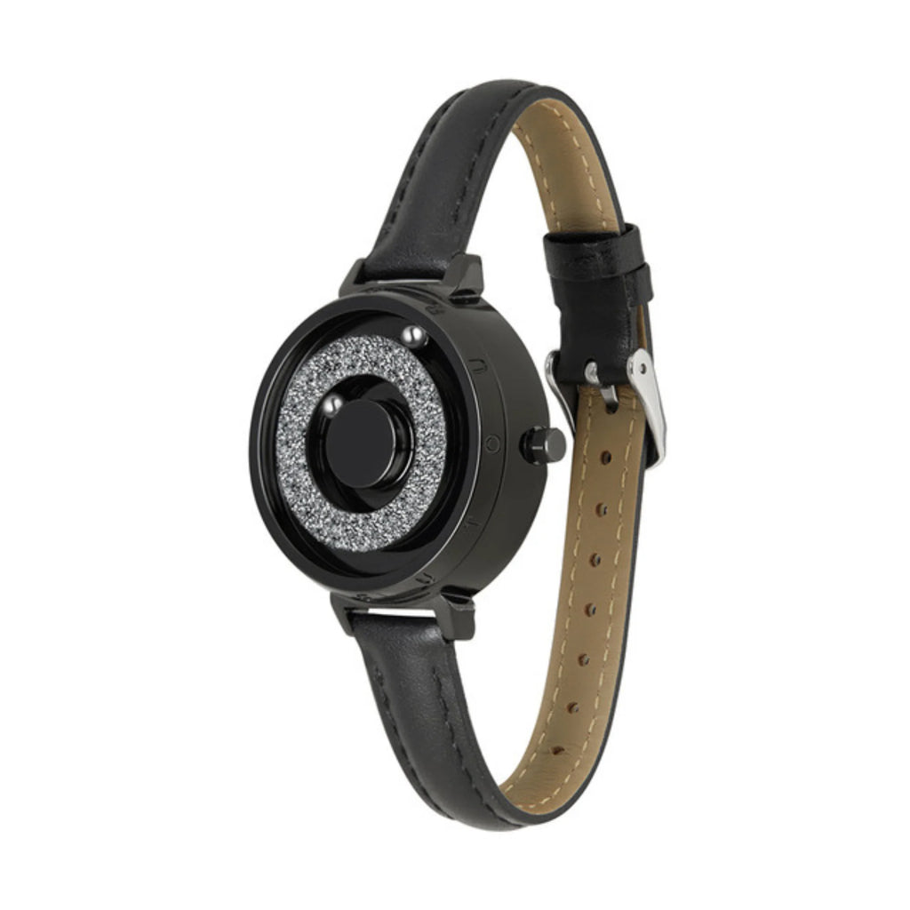 Schwarze Magnetuhr mit funkelndem Innenring und schwarzem Lederarmband.