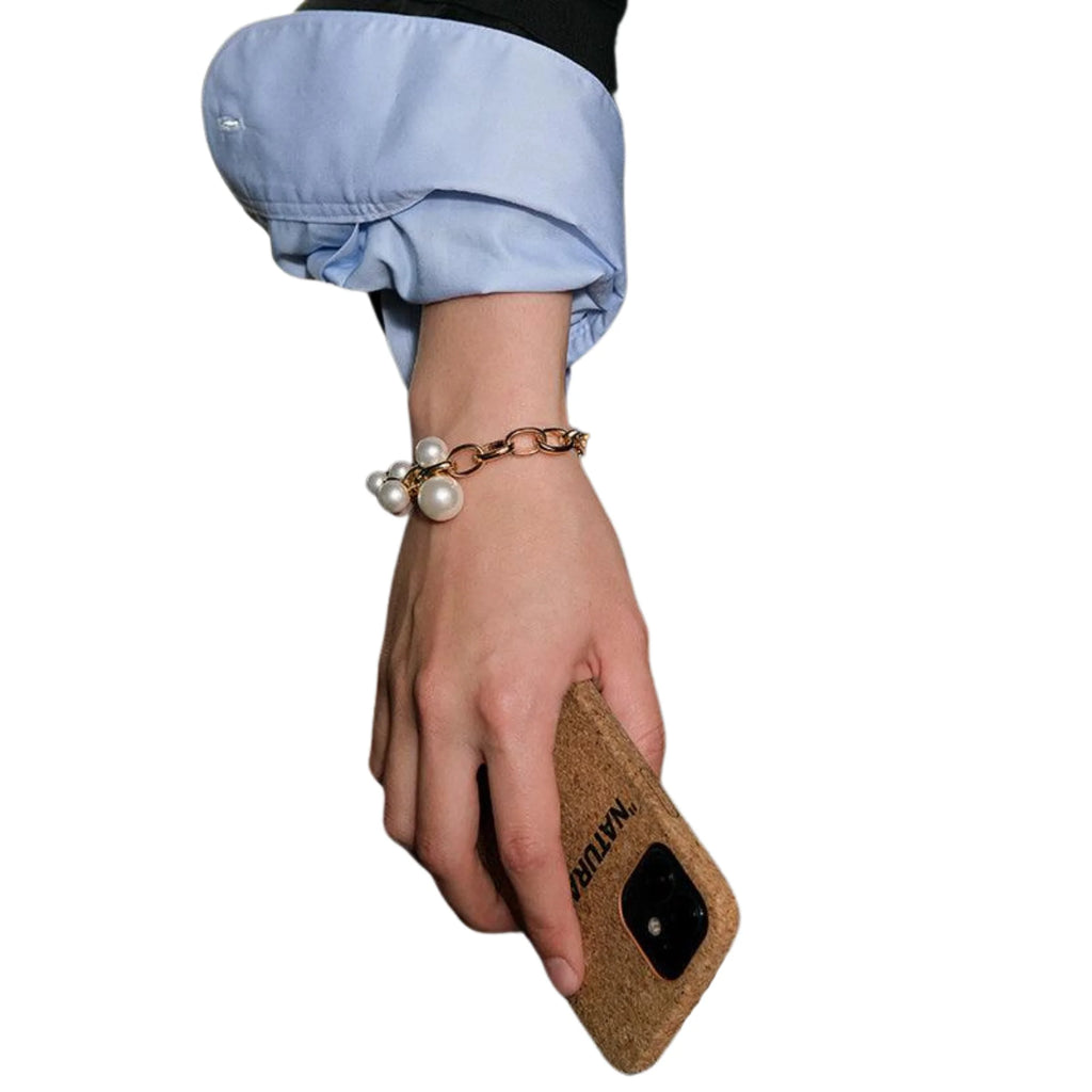 Armband mit Perlenbündel und Gliederdesign – sichtbar am Handgelenk, kombiniert mit Alltagsszene