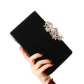 Florale Strass-Clutch in Schwarz – elegant in der Hand getragen mit weichem Samt-Finish