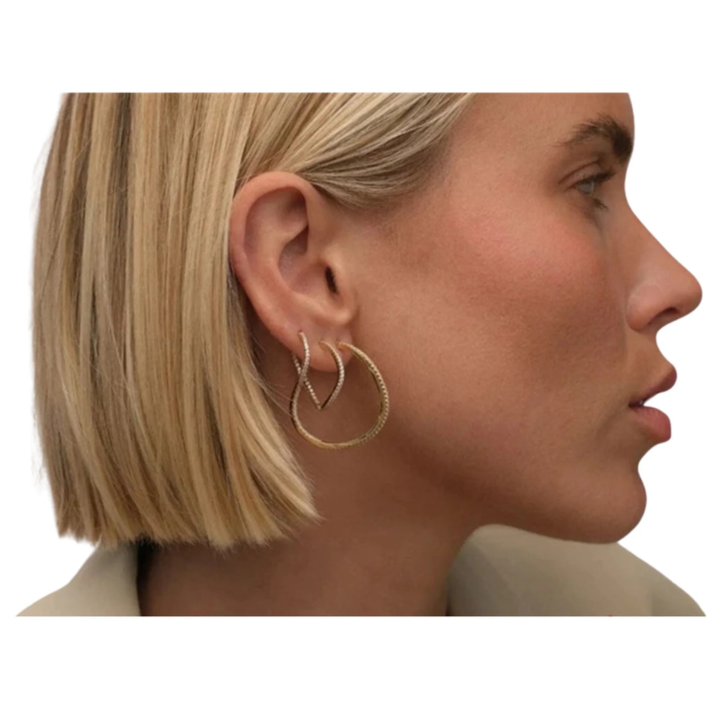 V-Ohrringe in Gold und Silber nebeneinander getragen – offene Form am Ohr sichtbar