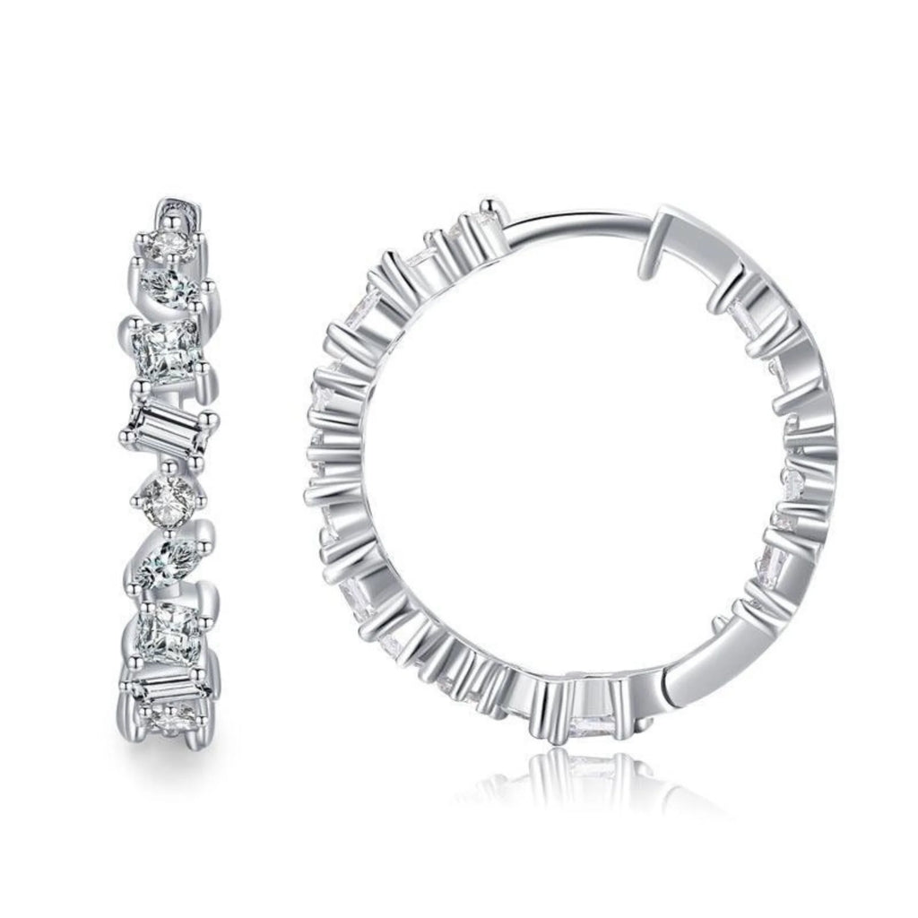 Ohrhänger mit wechselnden Steinschliffen in strukturierter Rundfassung – kein Glanz, nur Fläche.