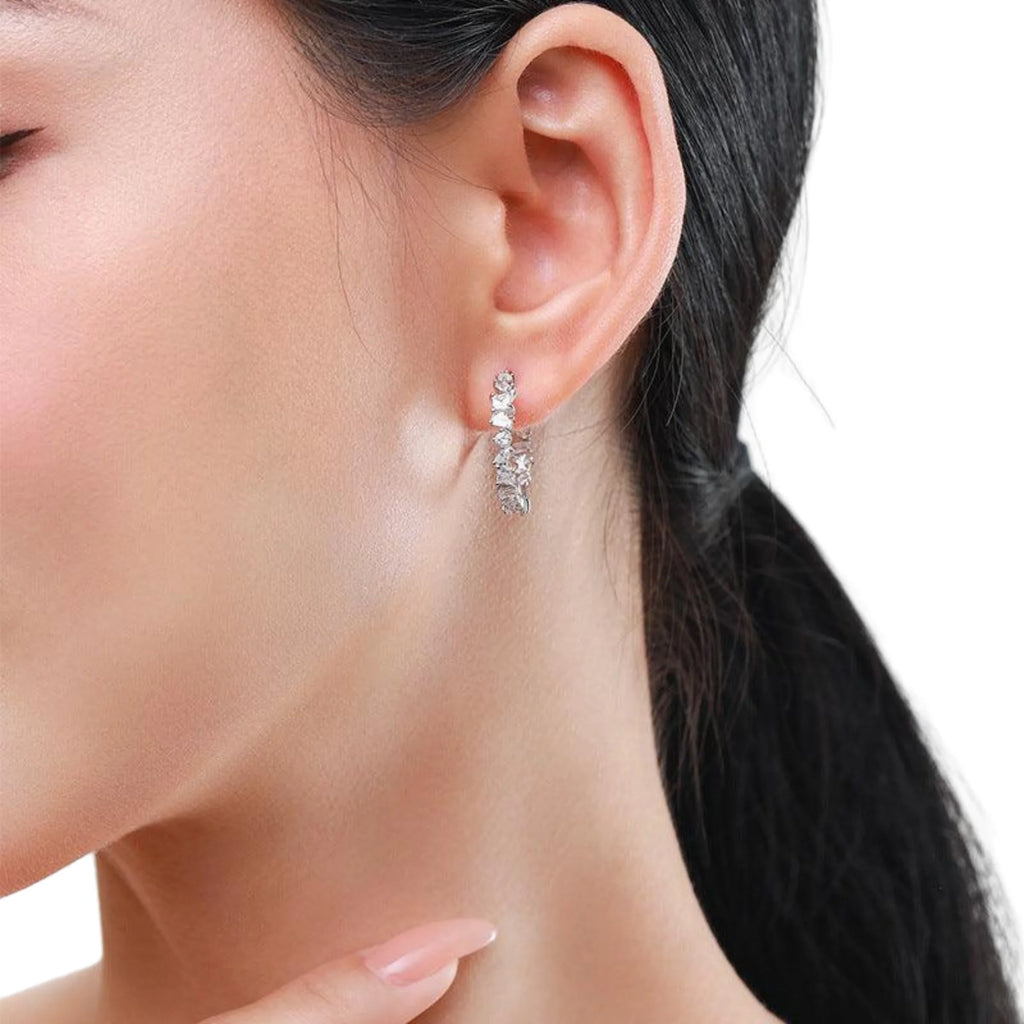 Silberner Ohrhänger mit Zirkonia-Akzenten, getragen am Ohr ohne Bühne.