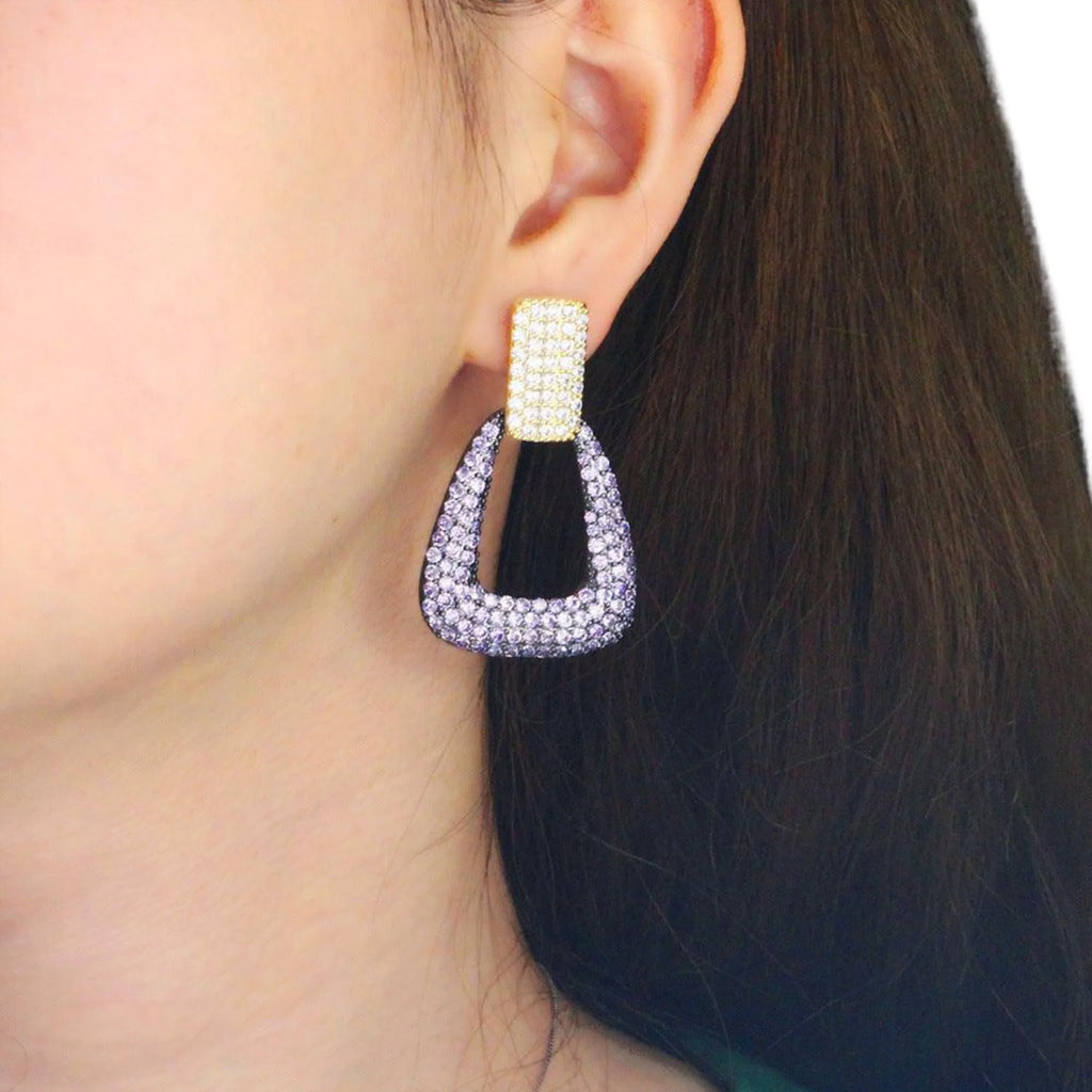 Getragene Ohrhänger mit violettem Kristallbesatz in geometrischer Form