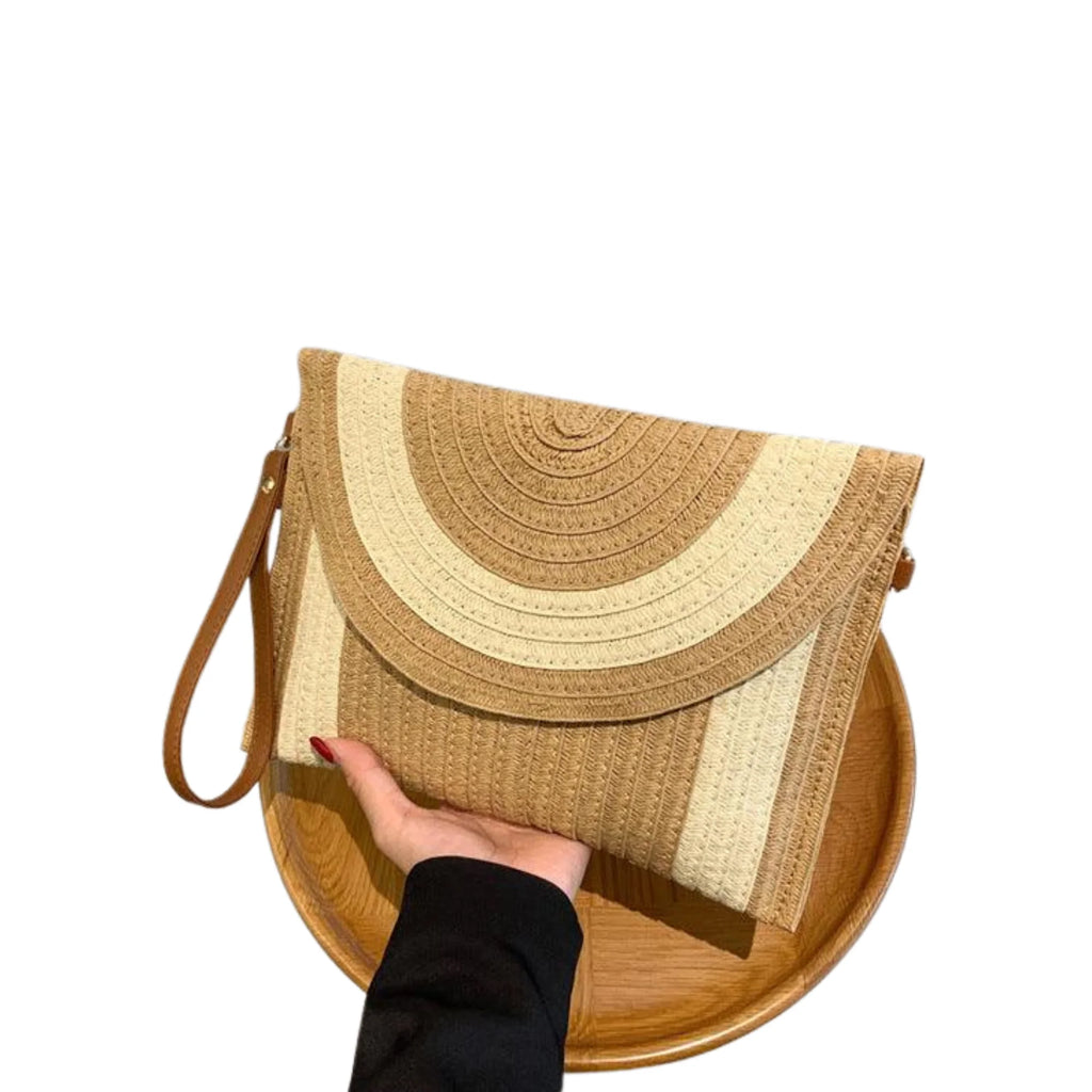 Hand hält strukturierte Colorblock-Tasche aus Papiergarn über einem Holzteller – natürlich und reduziert