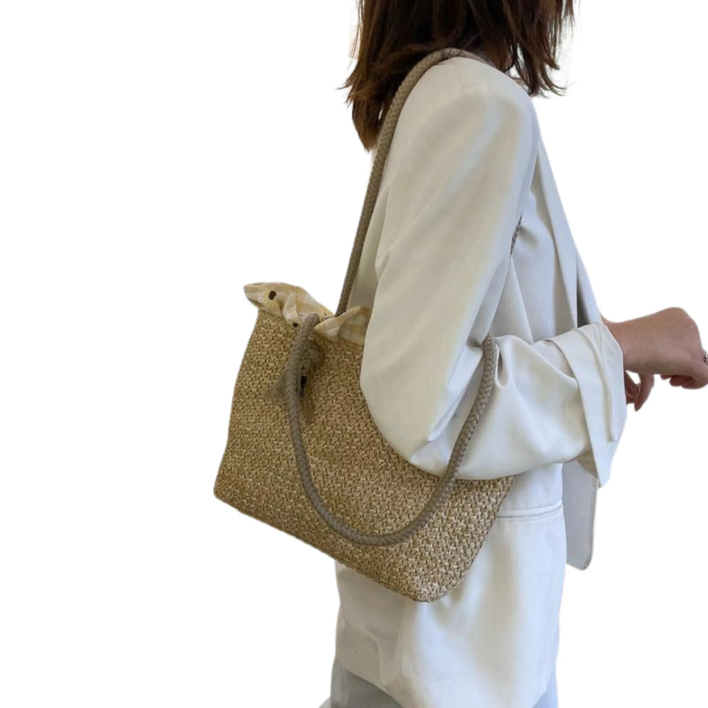 Schultertasche aus Strohgeflecht in vertikaler Ausrichtung, getragen mit weichem Henkel