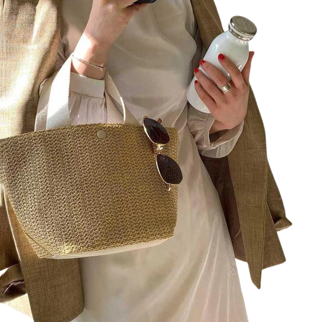 Rattantasche in hellem Beige (Ivory Wheat) mit breitem Gurt – Szene mit Flasche und Sonnenbrille