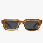 Rechteckige Sonnenbrille mit dunklen Gläsern und hornfarbener Fassung.