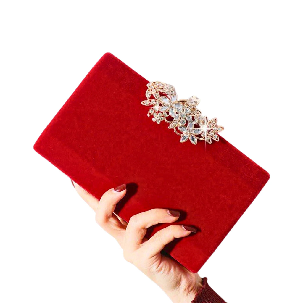 Rote Samt-Clutch mit floraler Strassblüte – strahlend in der Hand, perfekt zum festlichen Kleid