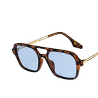 Rechteckige Sonnenbrille mit blauen Gläsern und schildpattfarbenem Rahmen – Doppelsteg in Gold, stilfrei getragen