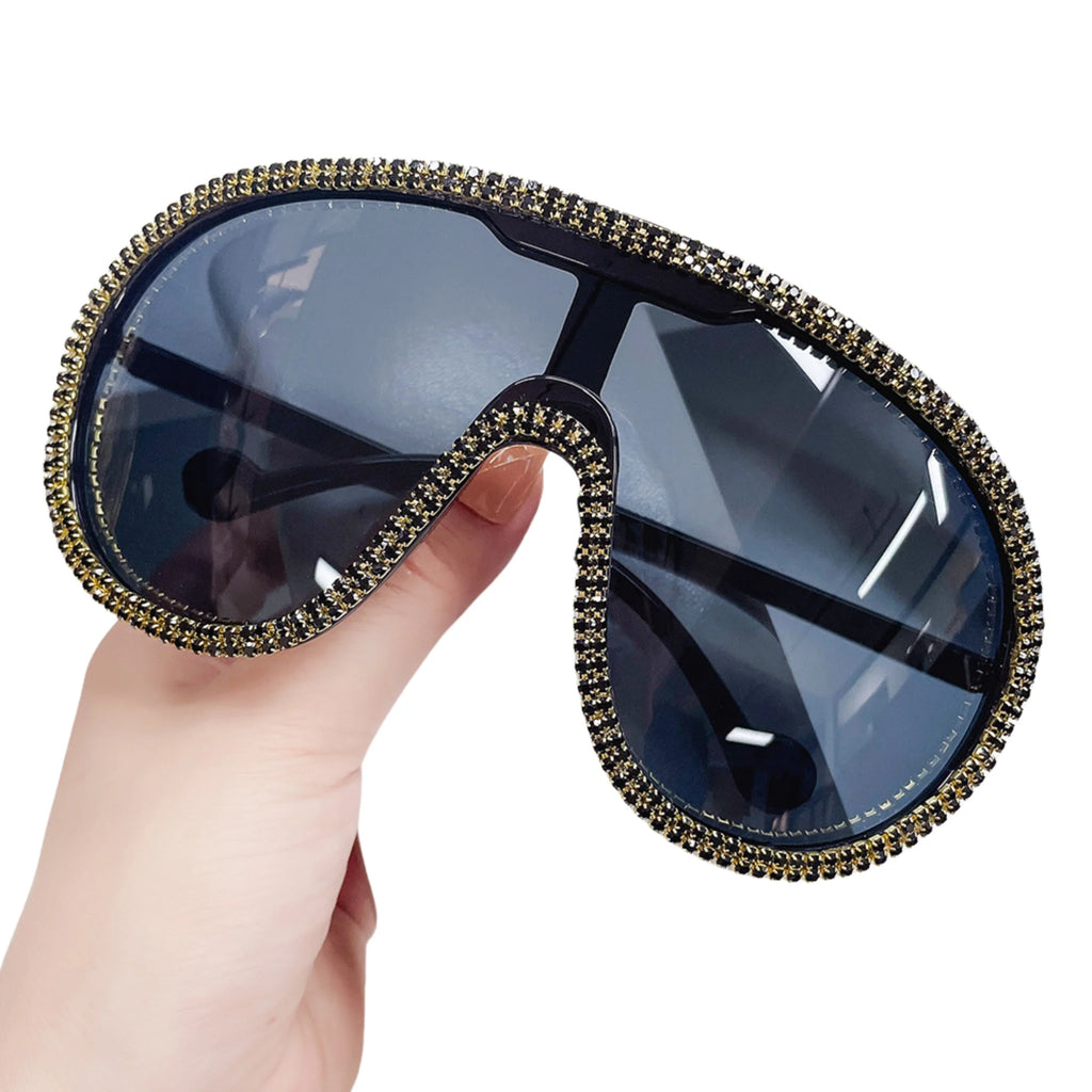 Sonnenbrille mit schwarzem Glas und goldfarbenem Kristallrand – blockige Fläche, markenfrei