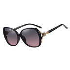 Schwarze Oversize-Sonnenbrille mit weichem Farbverlauf und floralem Bügeldetail.